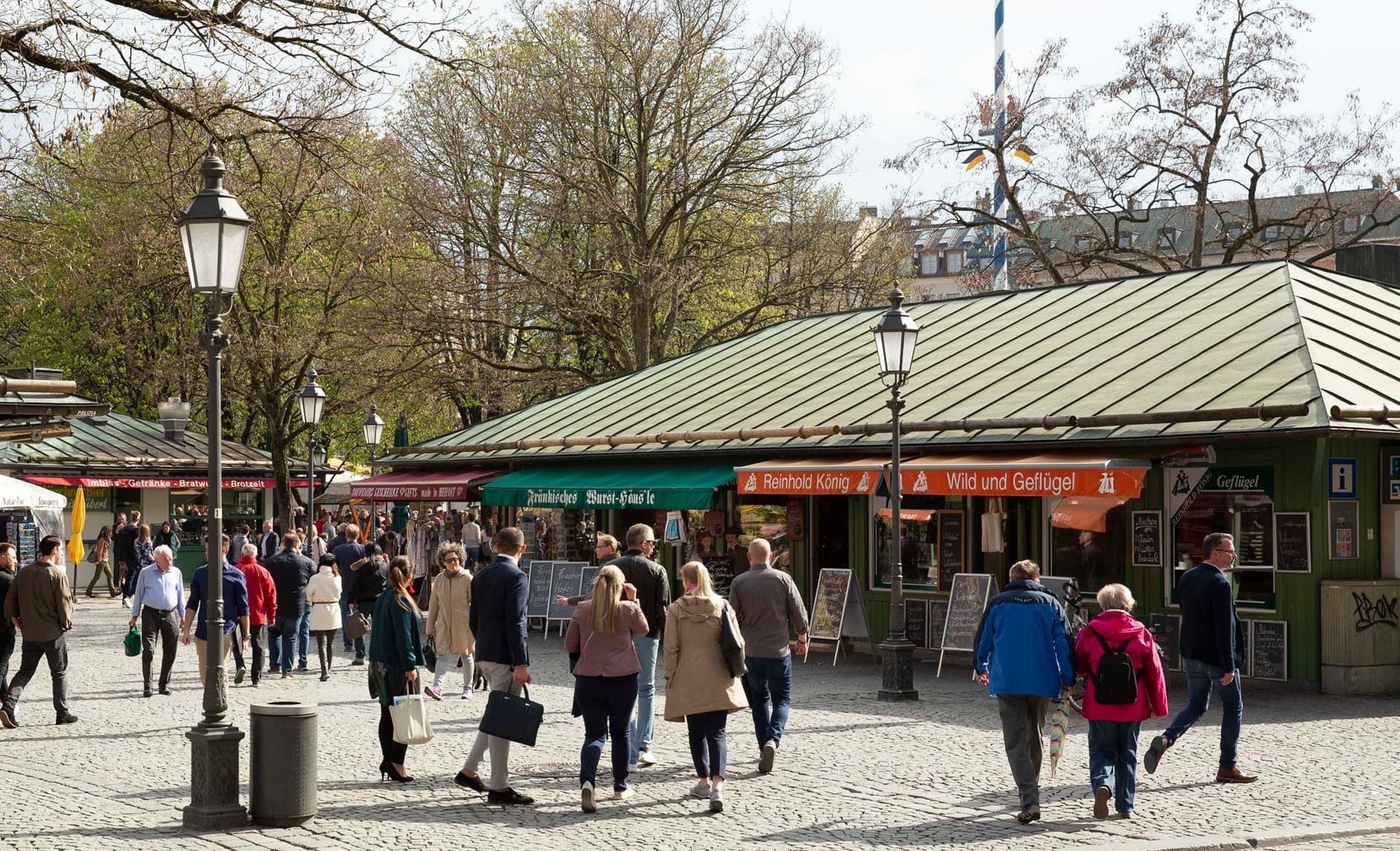 Marktstände auf dem Viktualienmarkt mit Passanten auf dem Kopfsteinpflaster