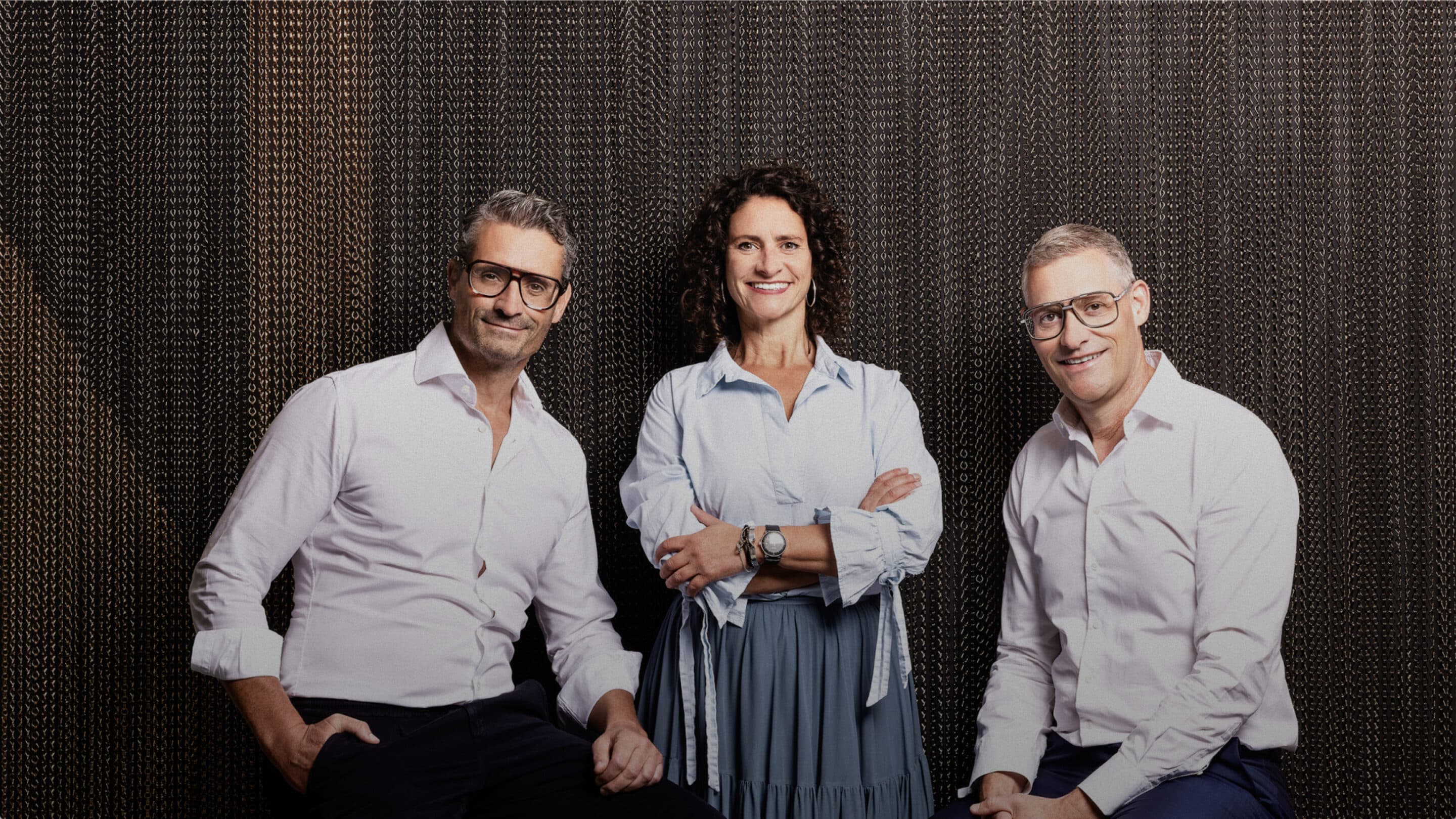 Das Team von Bucher Properties vor einem dunklen Vorhang