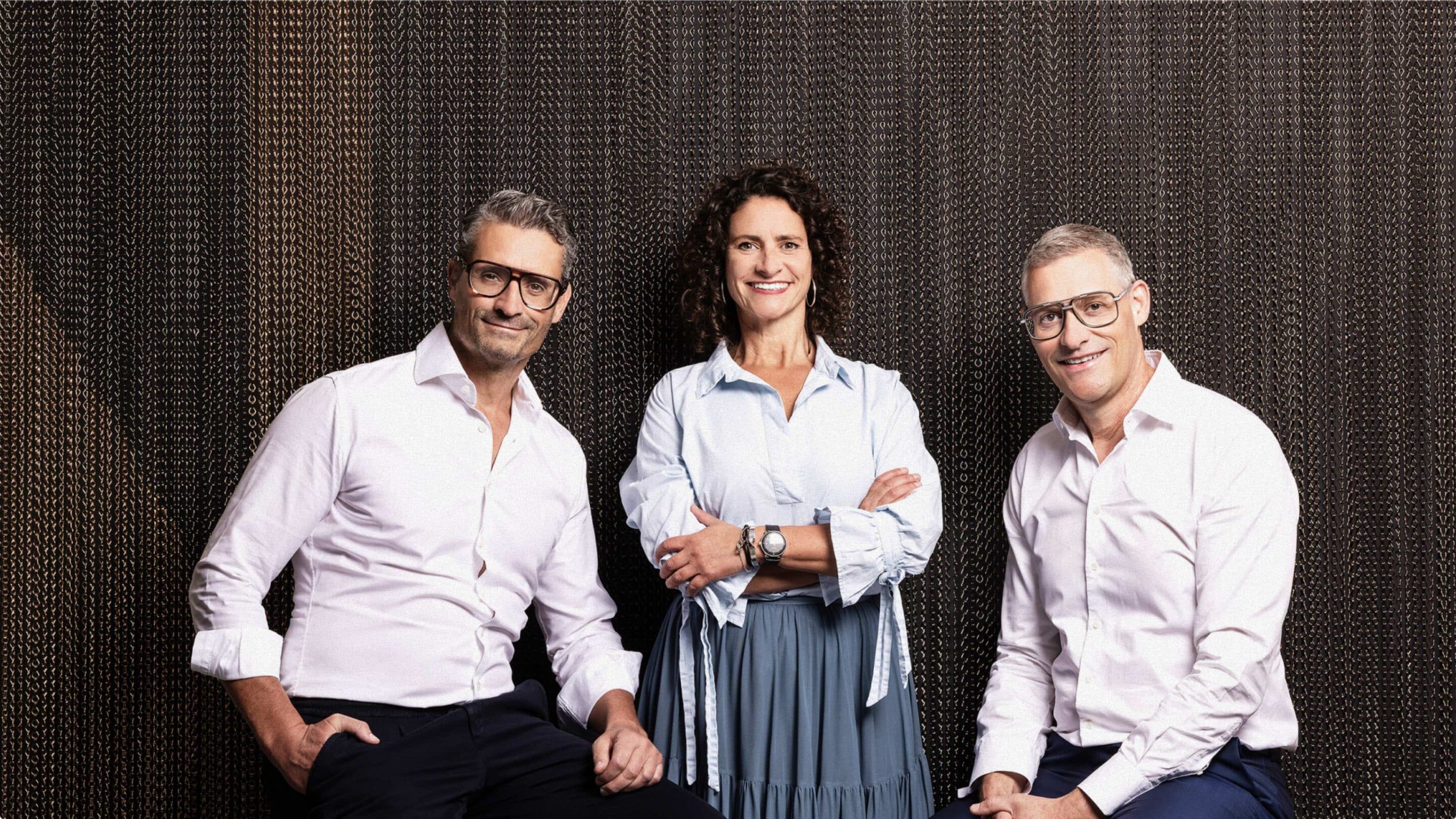 Robert, Birgit und Martin Bucher vor einer messingfarbenen Kettenvorhangwand