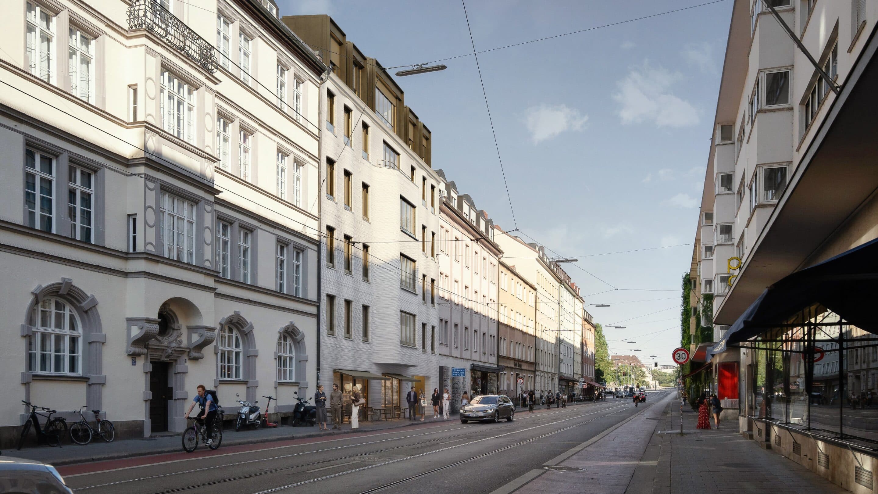 Blick die Fraunhoferstraße hinauf: Altbaufassaden, Trambahngleise und der helle Neubau des Glockenhofer mit Café im Erdgeschoss